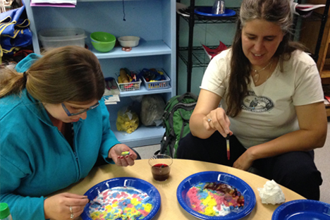 Two student instructors experiment with creative coloring methods.